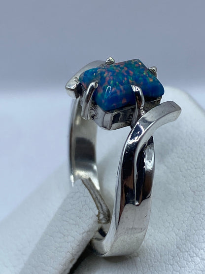 Anillo ópalo de fuego en la mano mostrando el juego de color azul