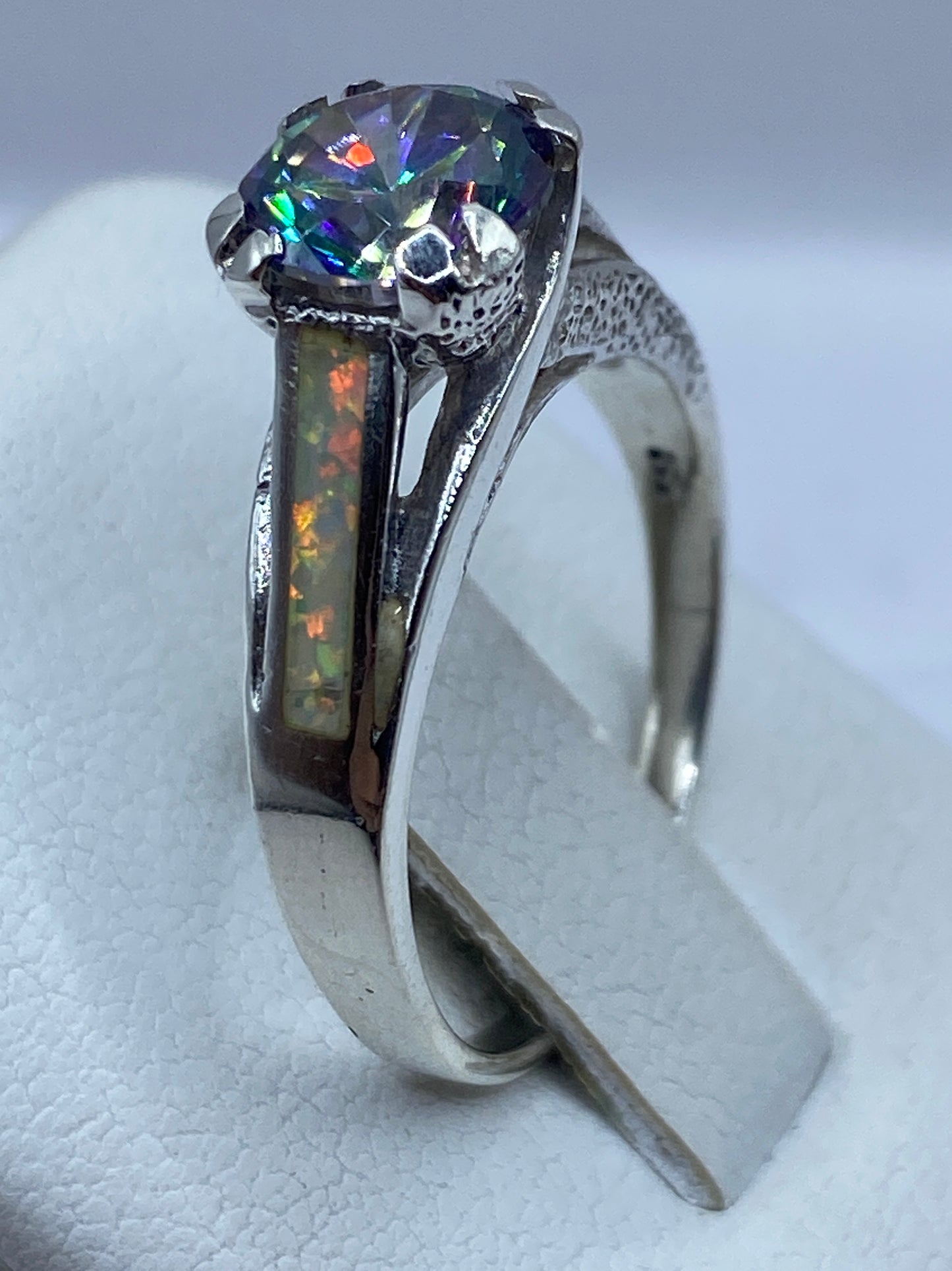 Detalle del ópalo de fuego con juego de colores rojo, verde, azul y dorado bajo luz natural