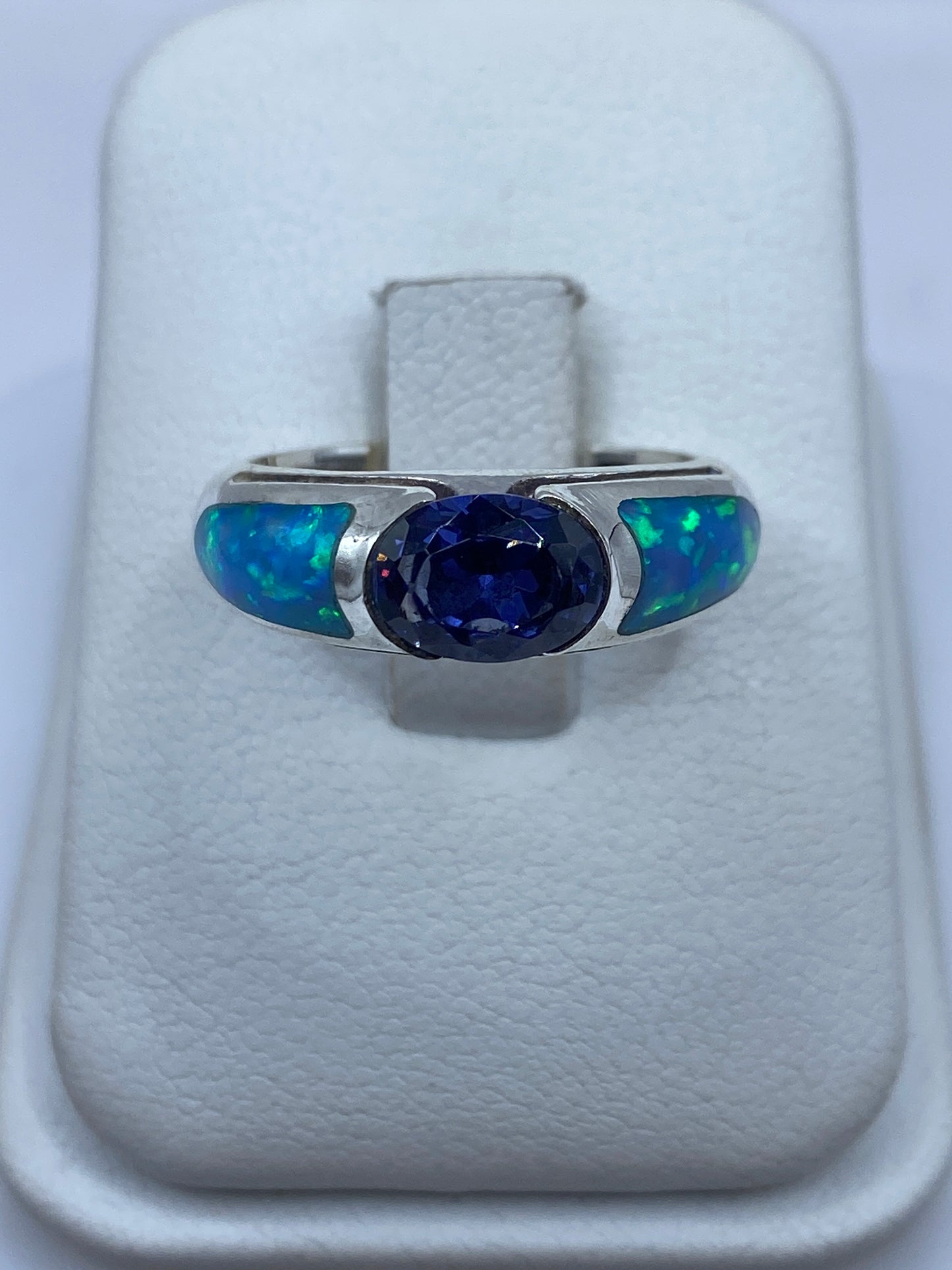 Anillo de plata .950 con ópalo de fuego azul en vista frontal sobre soporte blanco