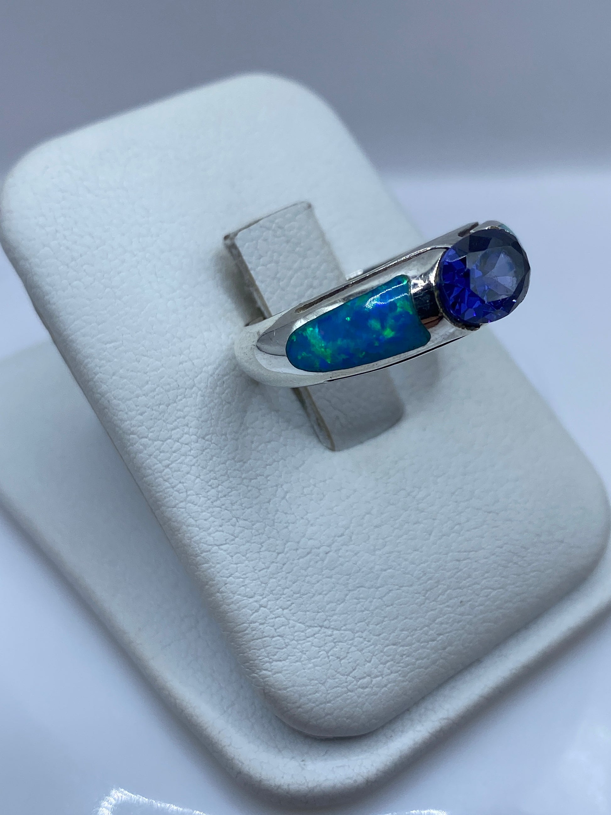 Detalle lateral del anillo mostrando el engaste asimétrico y el juego de color del ópalo
