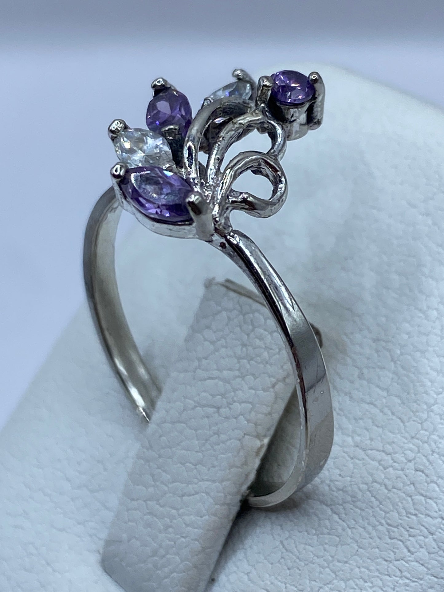 Anillo en la mano con la piedra morada brillando a la luz