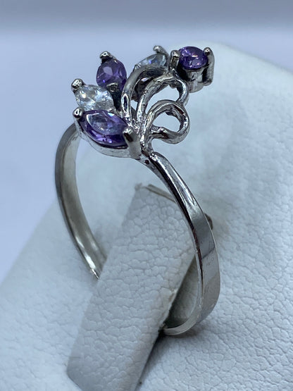 Anillo en la mano con la piedra morada brillando a la luz