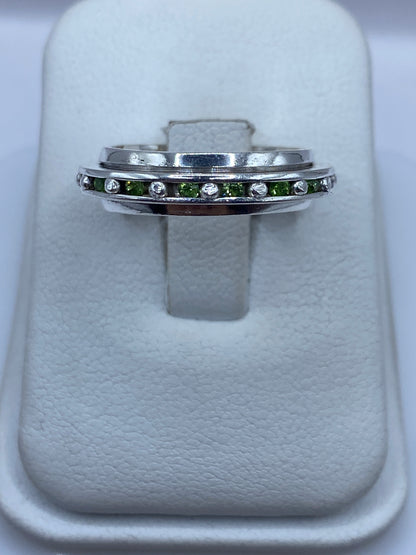 Anillo de plata eslabones con circonias verdes brillantes en mano de mujer