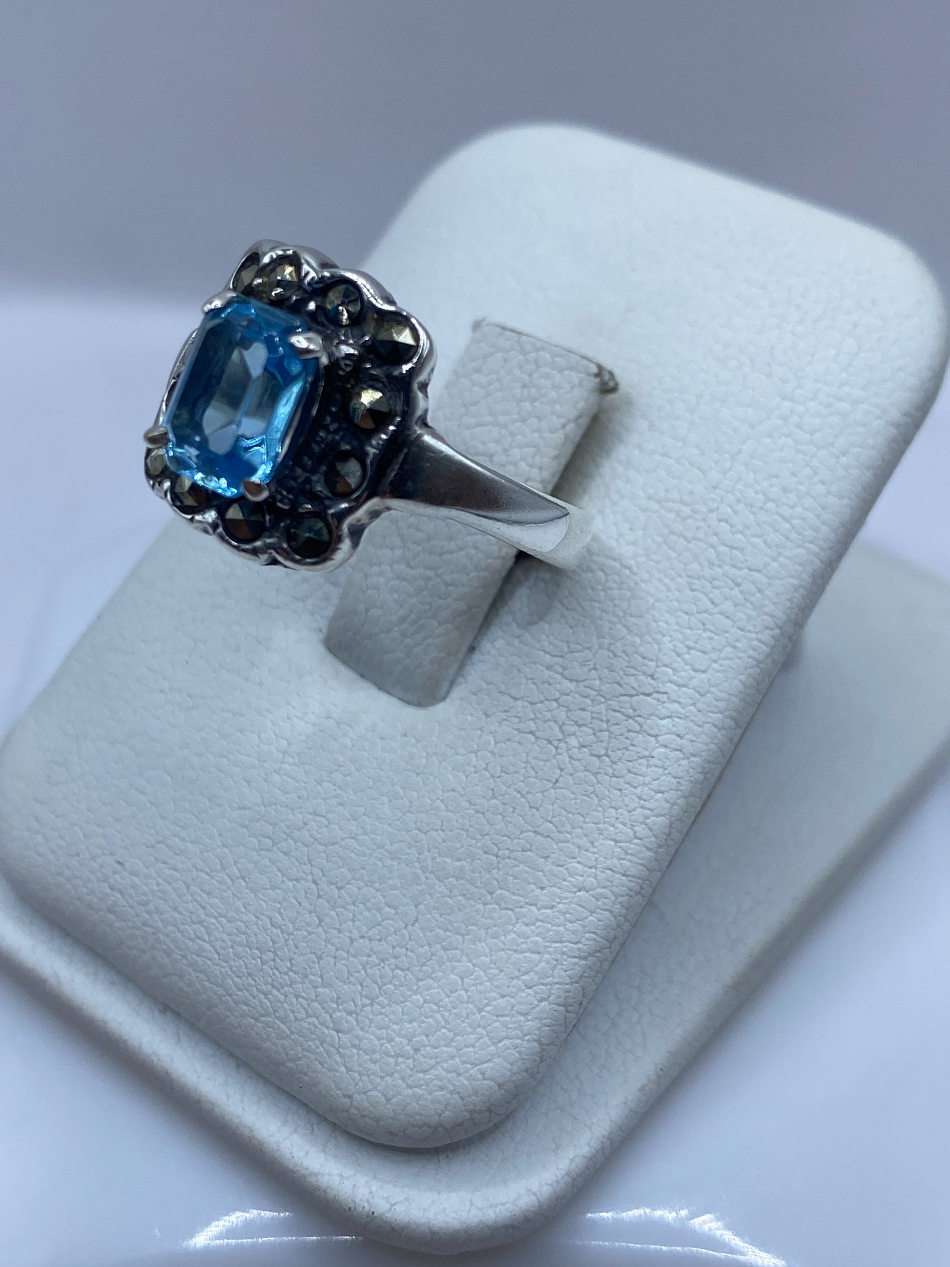 Detalle frontal del anillo mostrando la circonia azul facetada en engaste de plata