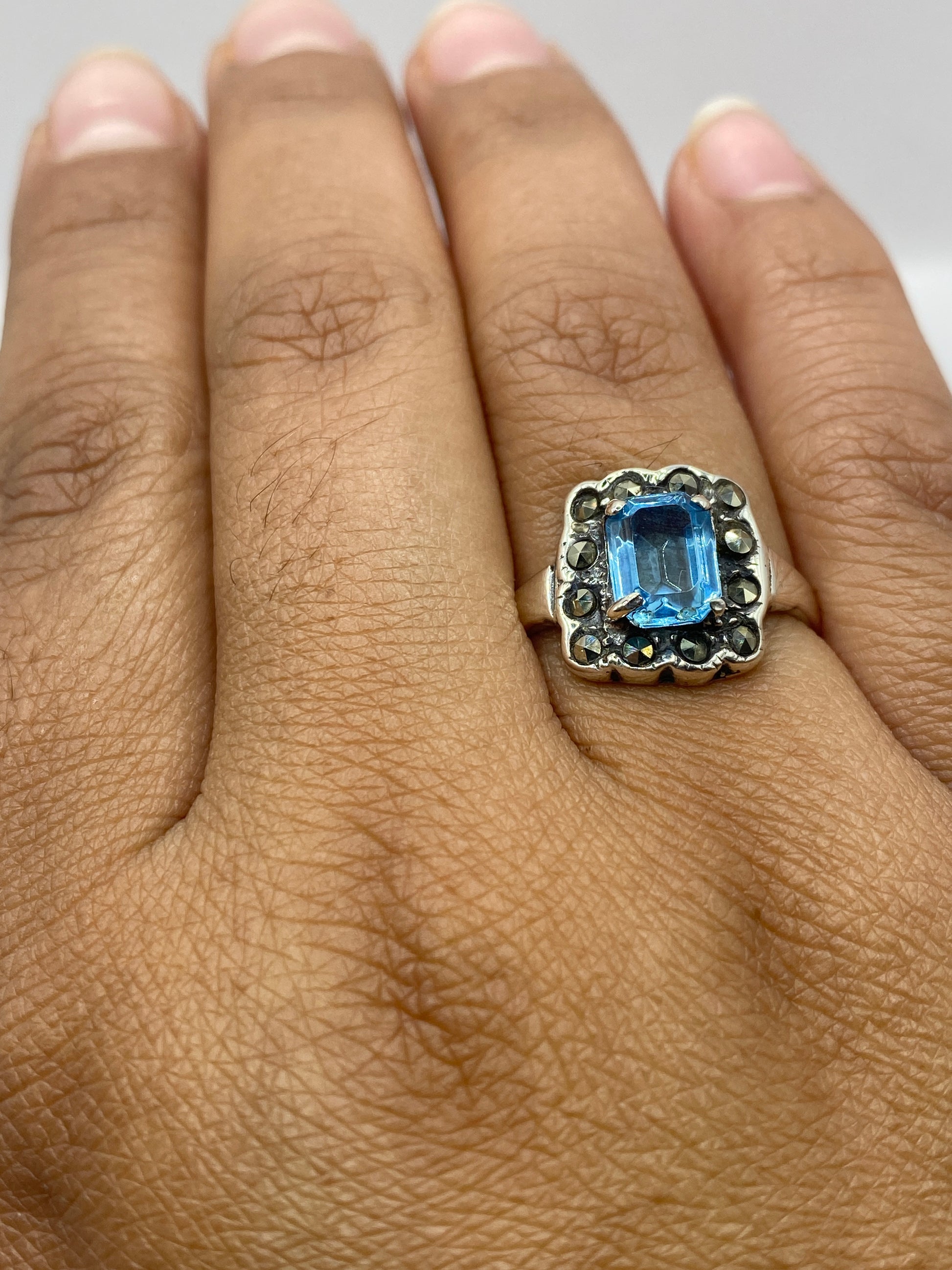 Anillo sobre fondo plateado mostrando el brillo azul cielo de la circonia