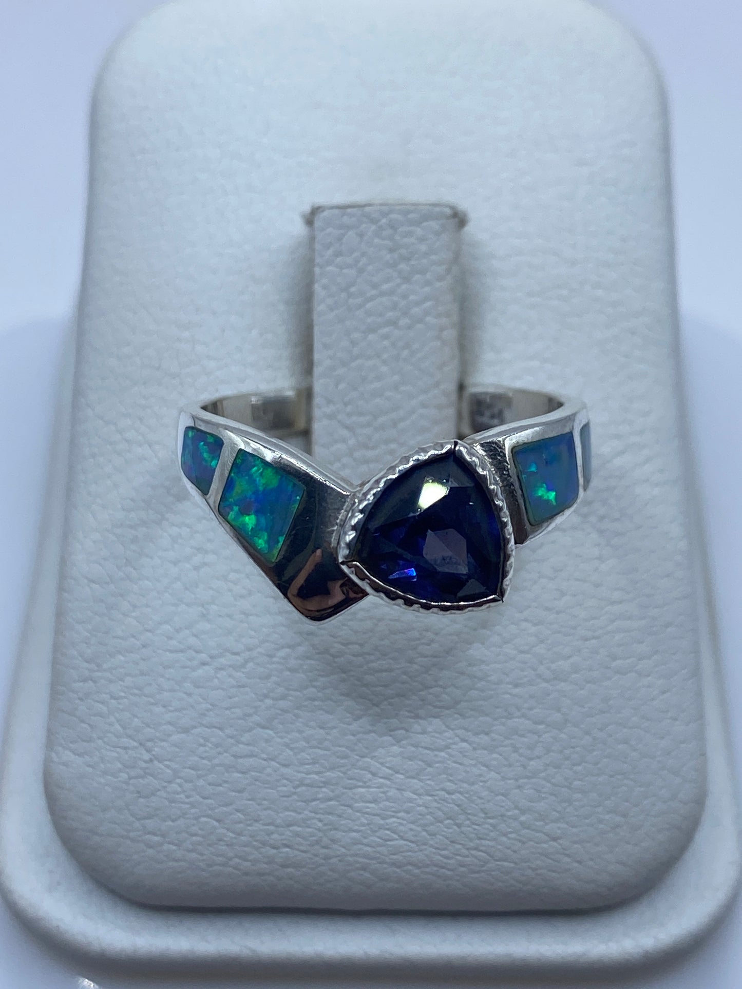 Anillo de plata .950 con ópalo de fuego azul sobre blanco, mostrando el fuego natural de la piedra