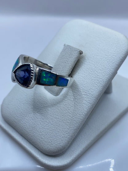 Vista lateral del anillo unisex en plata pura, detalle del engaste a mano del ópalo