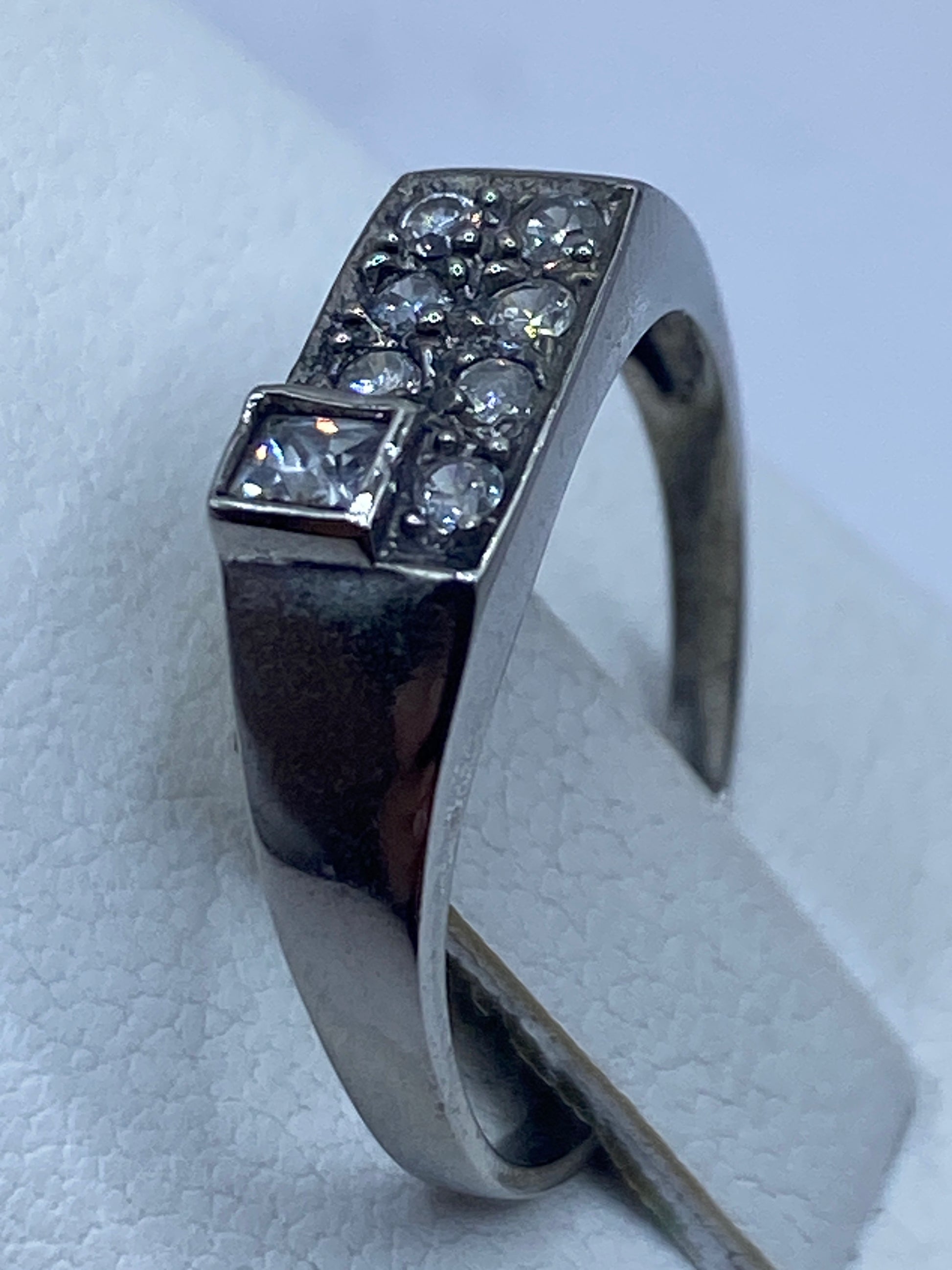 Anillo de plata en el dedo de una mujer, luz natural resaltando el brillo de la piedra