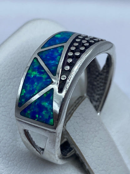 Anillo en dedo mostrando el brillo y los reflejos azules del ópalo de fuego