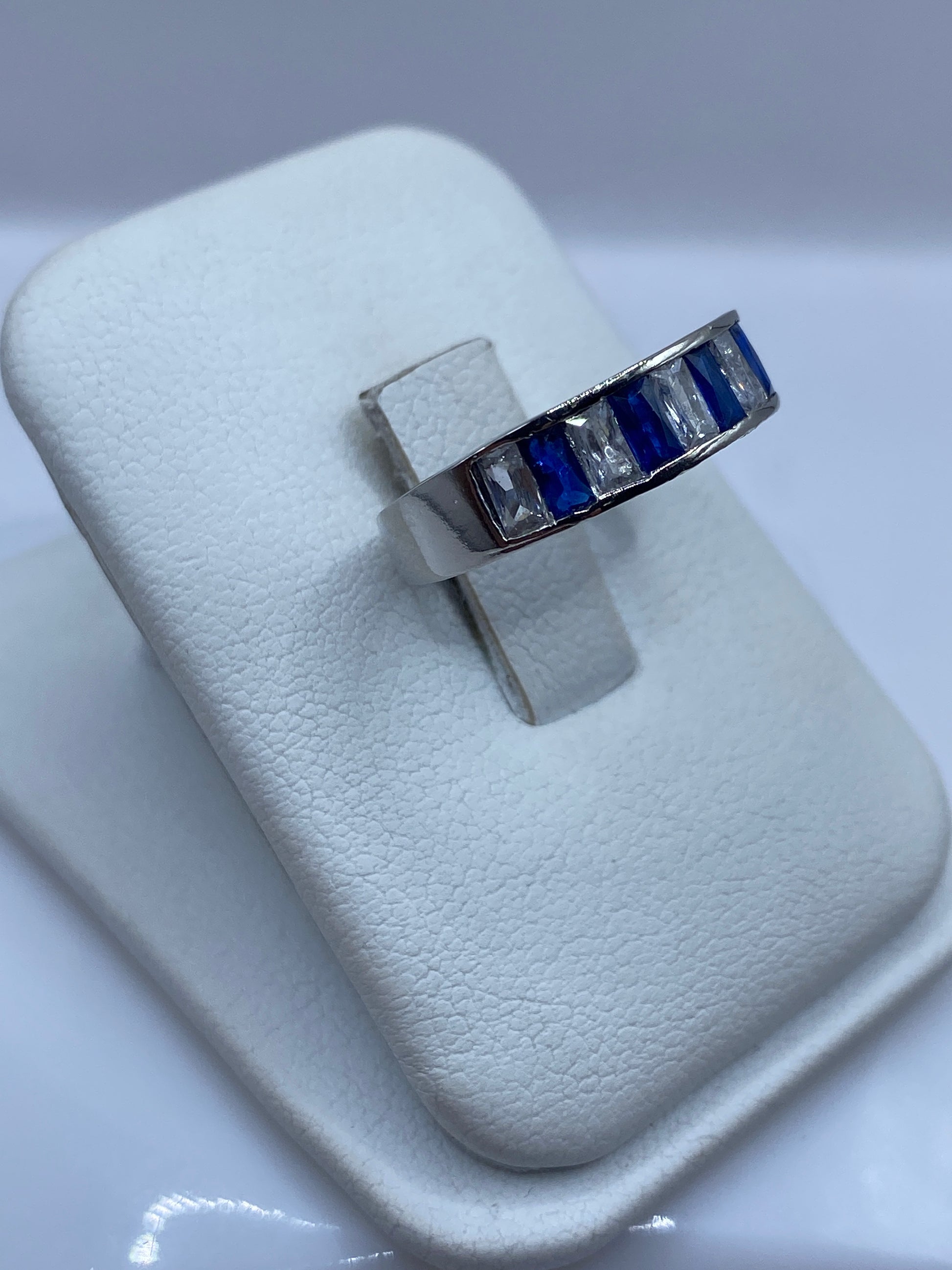 Vista lateral del anillo de banda fina con circonia azul brillante