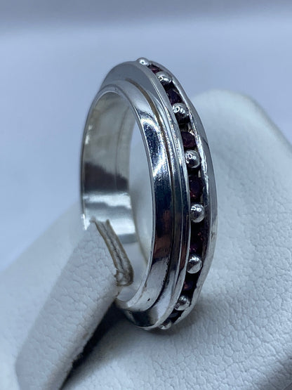Anillo de plata rosa puesto en dedo, luz natural mostrando brillo de la piedra