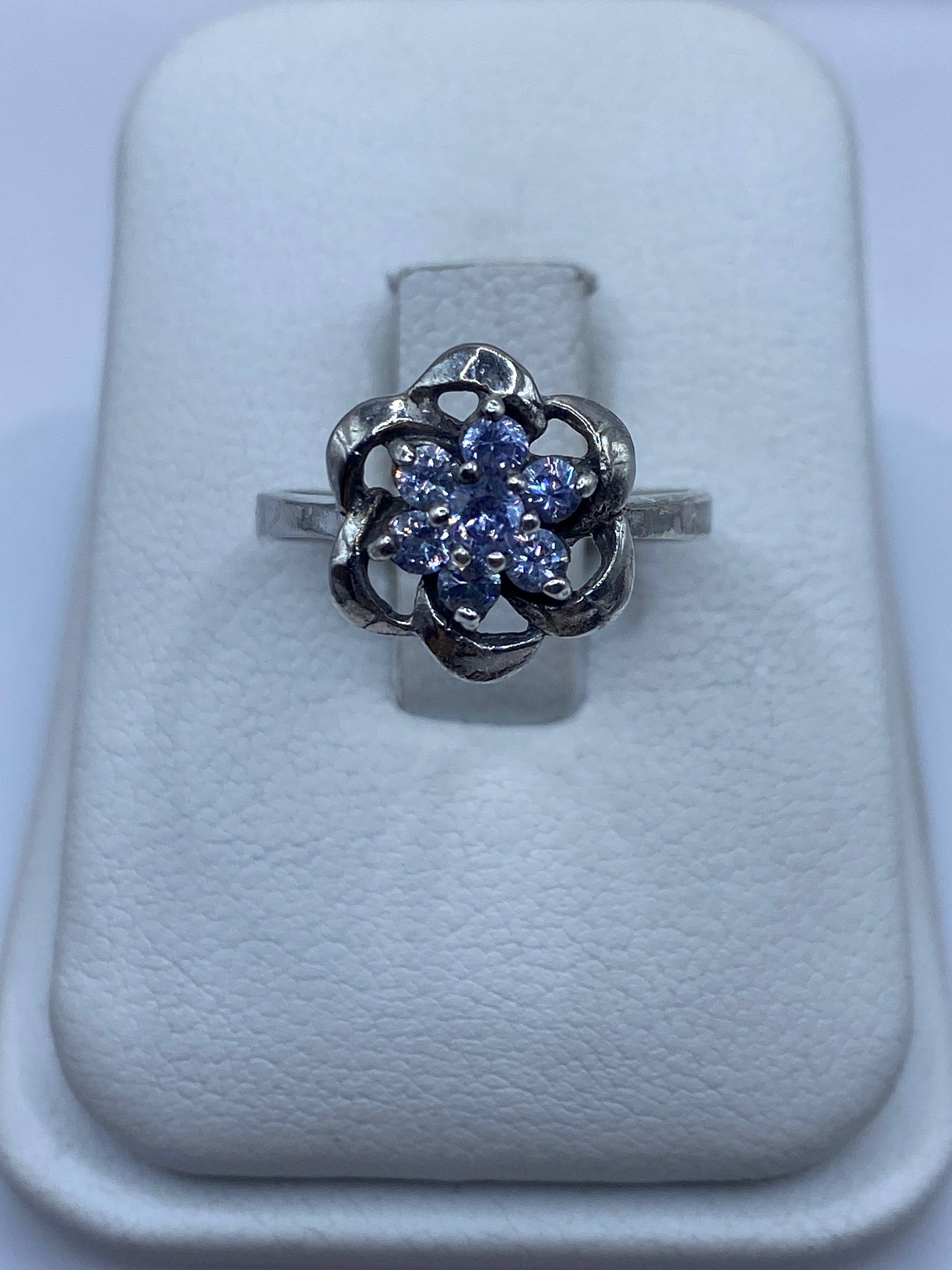 Anillo de plata floral con circonias multicolor en talla 6, mostrado en estuche blanco
