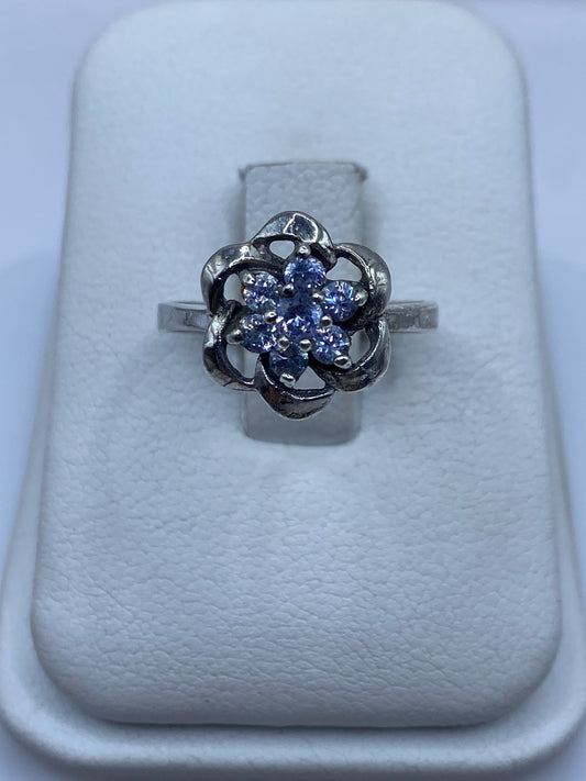 Anillo de plata floral con circonias multicolor en talla 6, mostrado en estuche blanco