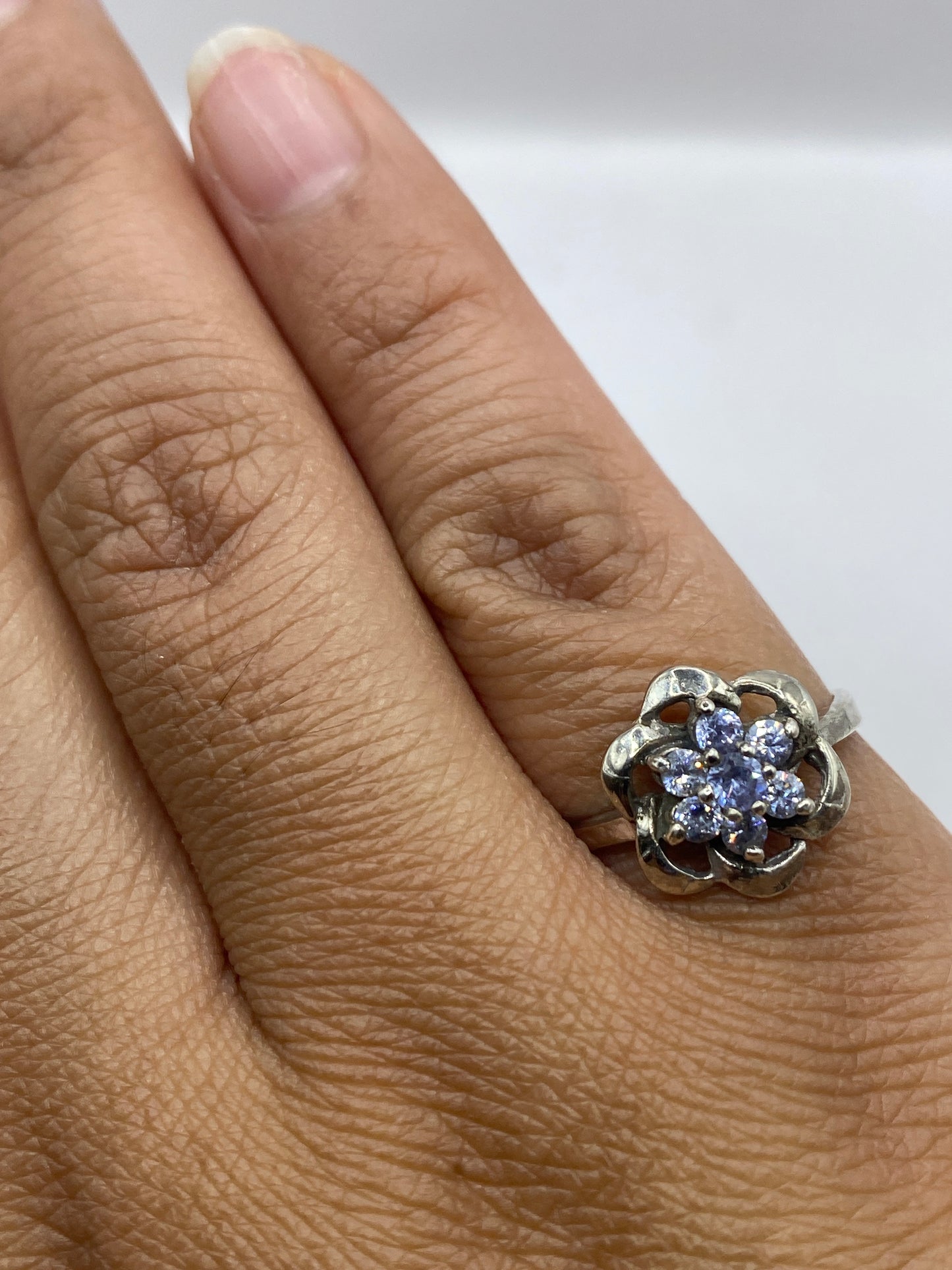 Anillo puesto en dedo, destacando el brillo y fuego de las circonias