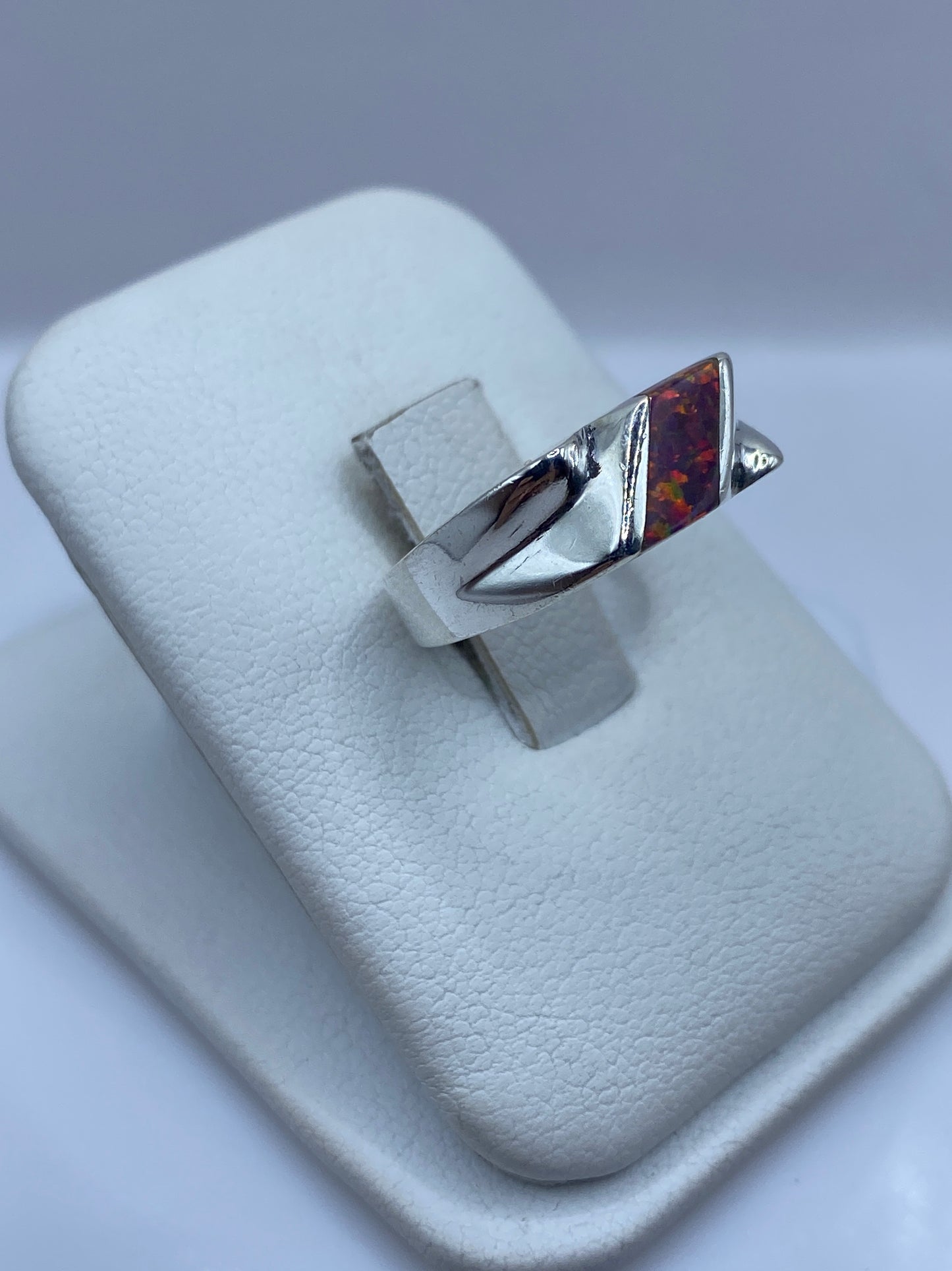 Anillo ópalo de fuego en perspectiva lateral, mostrando diseño escultural en plata .925