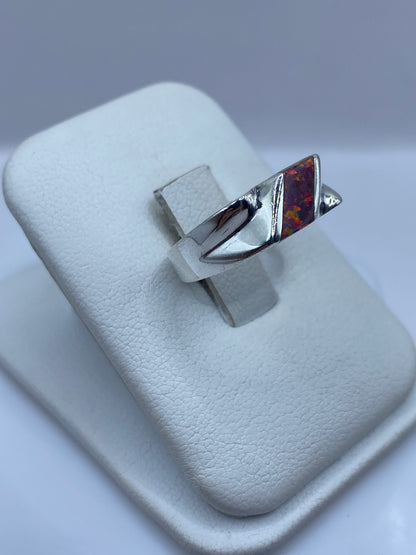 Anillo ópalo de fuego en perspectiva lateral, mostrando diseño escultural en plata .925