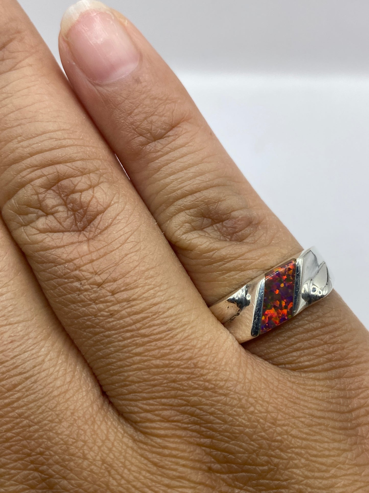 Anillo en dedo, mostrando sello de autenticidad .925 y el fuego natural del ópalo