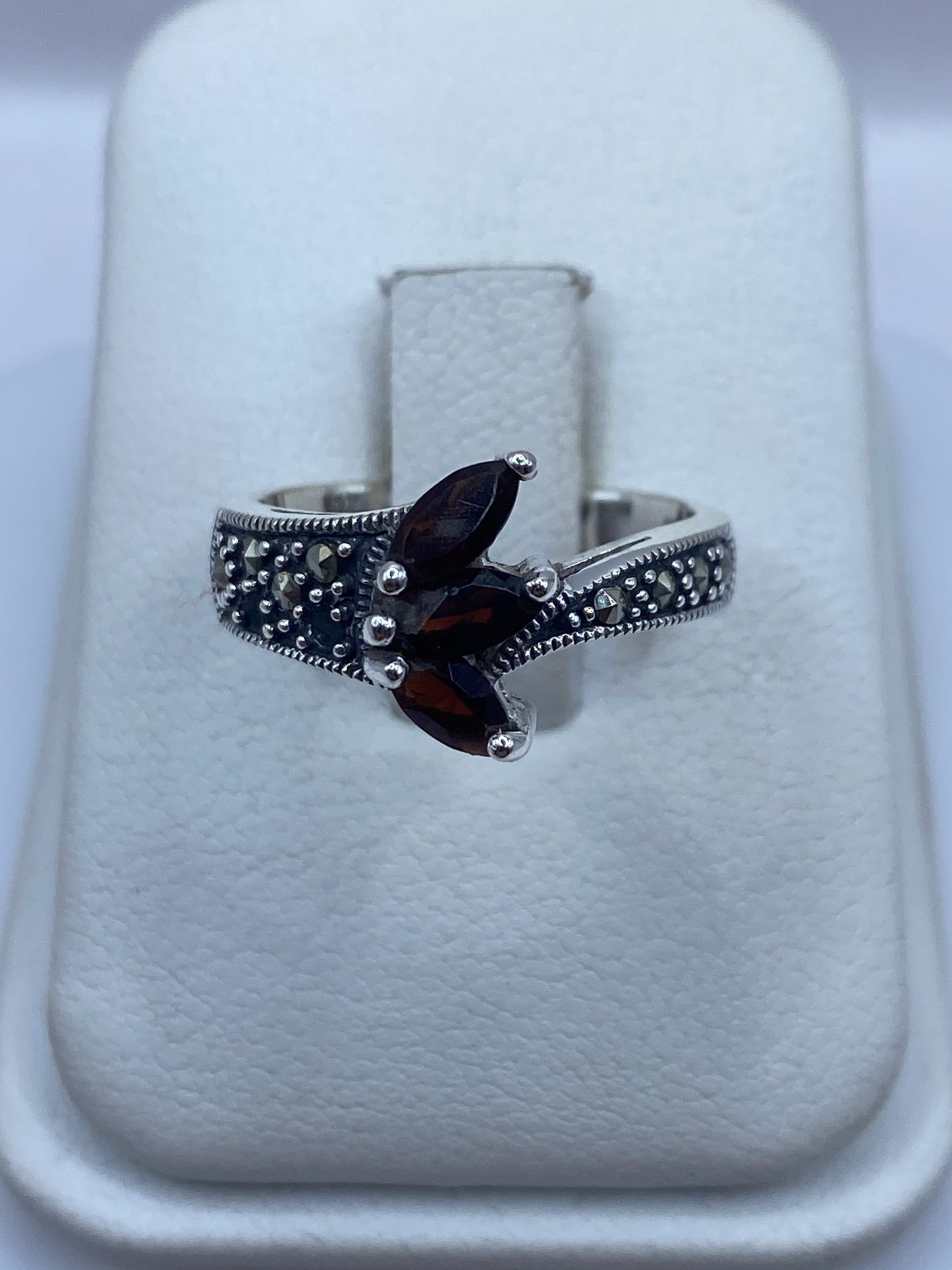Anillo de plata vintage con circonias café sobre fondo blanco, vista frontal