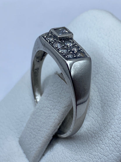 Detalle lateral del anillo de plata pulida con piedra circular brillante