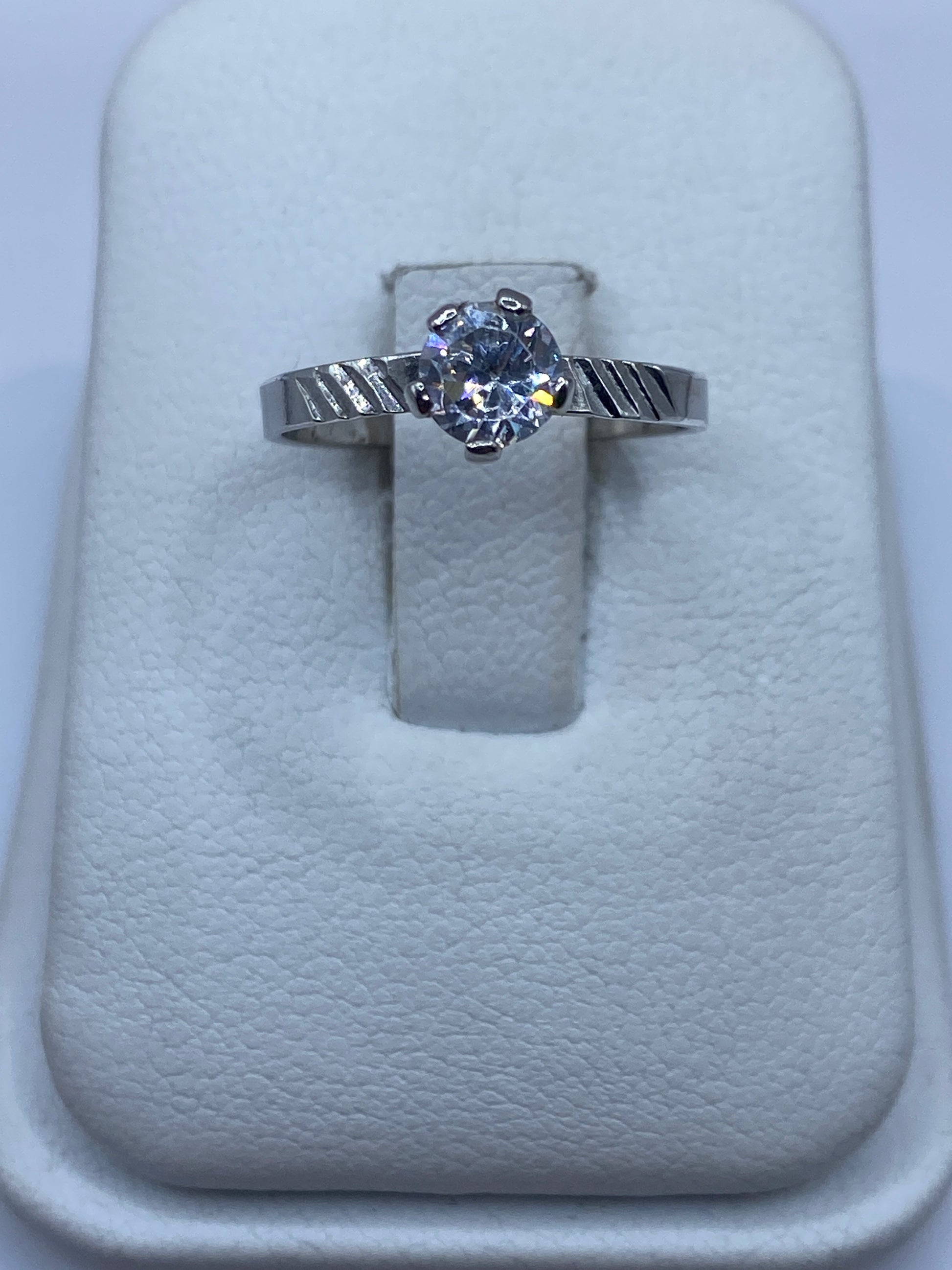 Anillo de plata solitario con circonia blanca brillante, vista frontal en estuche blanco