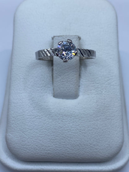 Anillo de plata solitario con circonia blanca brillante, vista frontal en estuche blanco