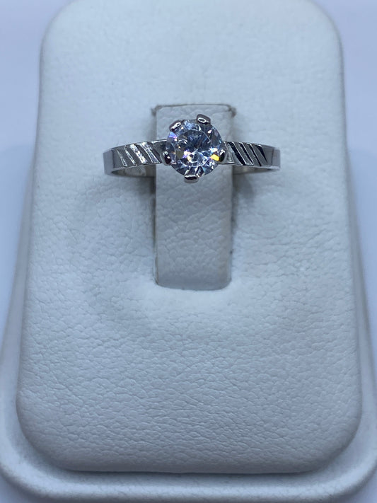 Anillo de plata solitario con circonia blanca brillante, vista frontal en estuche blanco