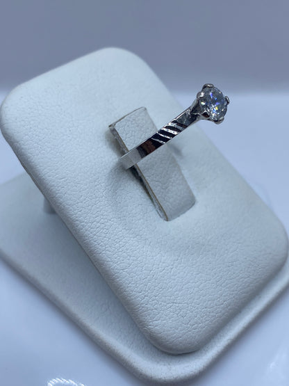 Anillo delicado de plata .925 con circonia blanca, vista lateral mostrando el engaste a mano