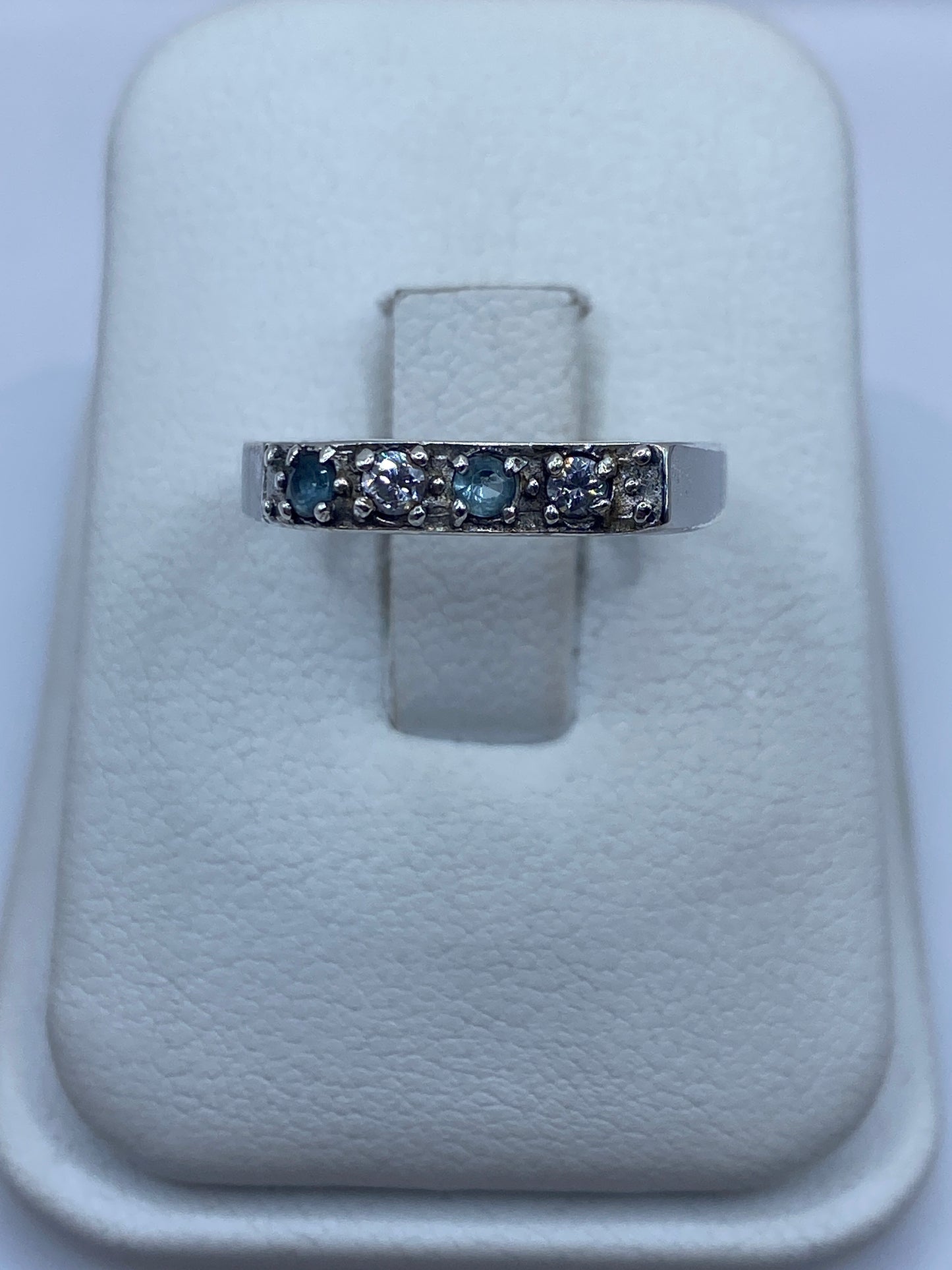 Anillo de plata minimalista con circonia azul cielo, vista frontal en estuche blanco