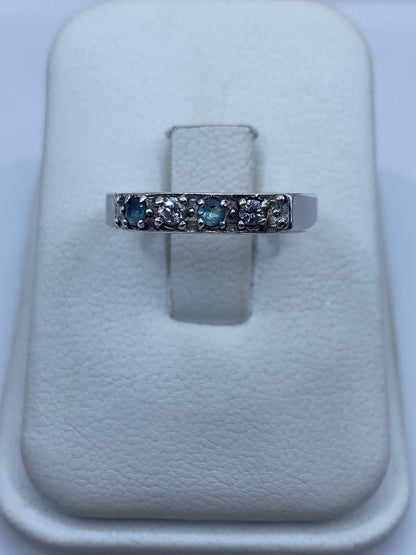 Anillo de plata minimalista con circonia azul cielo, vista frontal en estuche blanco