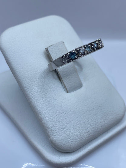 Anillo solitario de plata .925 sobre dedo, mostrando la circonia azul en luz natural