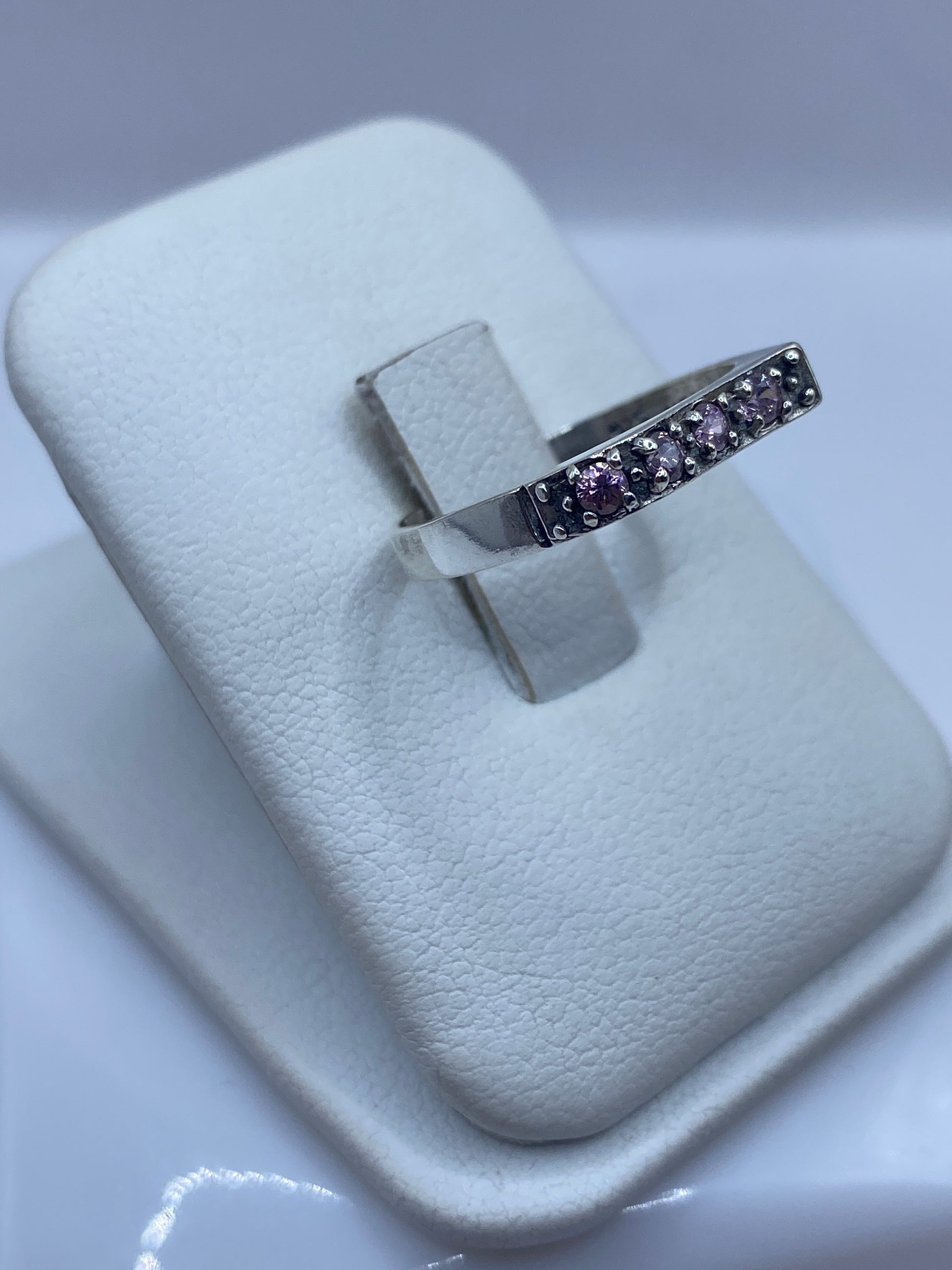 Vista lateral del anillo .925 con engaste de circonia rosa, banda delicada