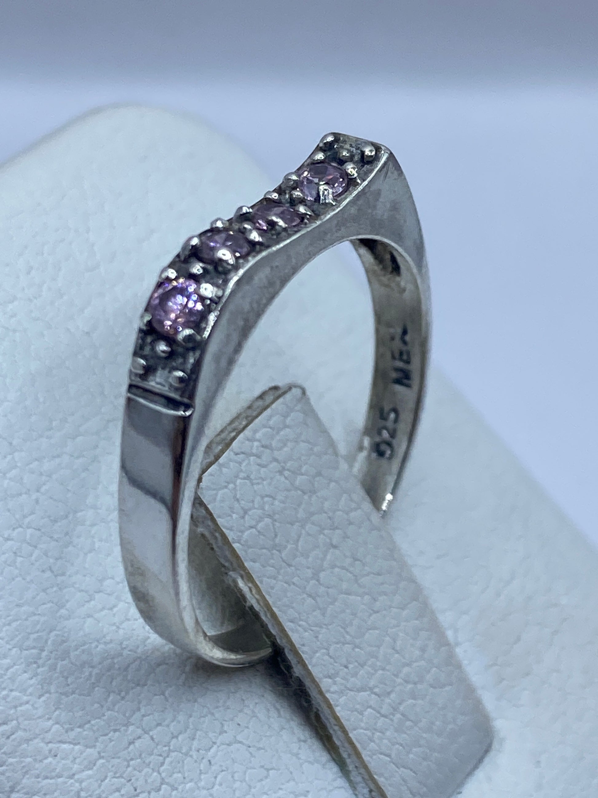 Detalle frontal de la circonia rosa facetada reflejando luz en anillo de plata Taxco