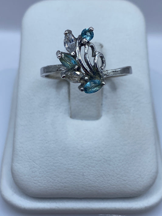 Anillo de plata solitario con circonia azul cielo en la mano de una mujer