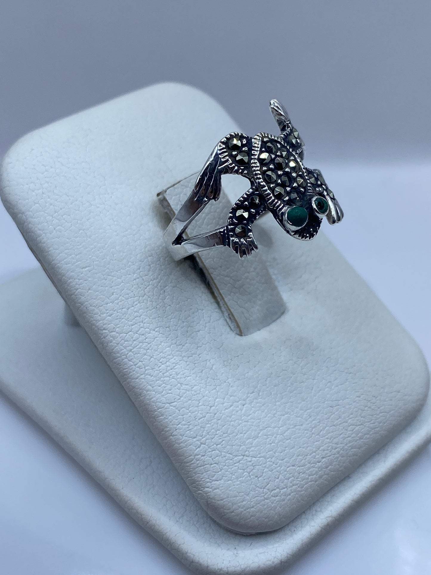Vista lateral del anillo búho en plata, destacando las alas y la textura prehispánica