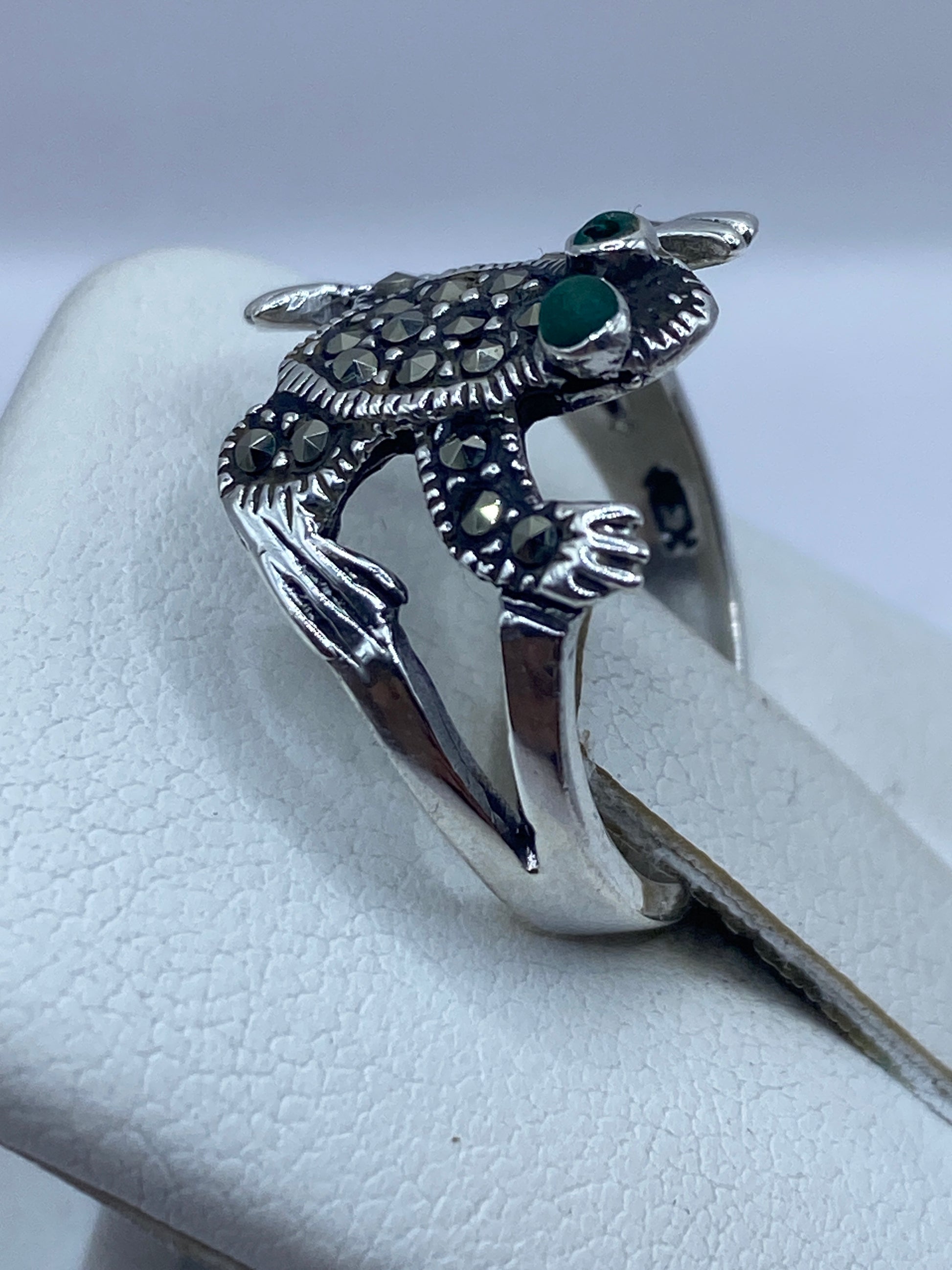Anillo búho en la mano de una mujer, mostrando la piedra verde en los ojos
