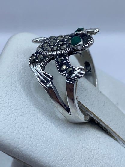 Anillo búho en la mano de una mujer, mostrando la piedra verde en los ojos