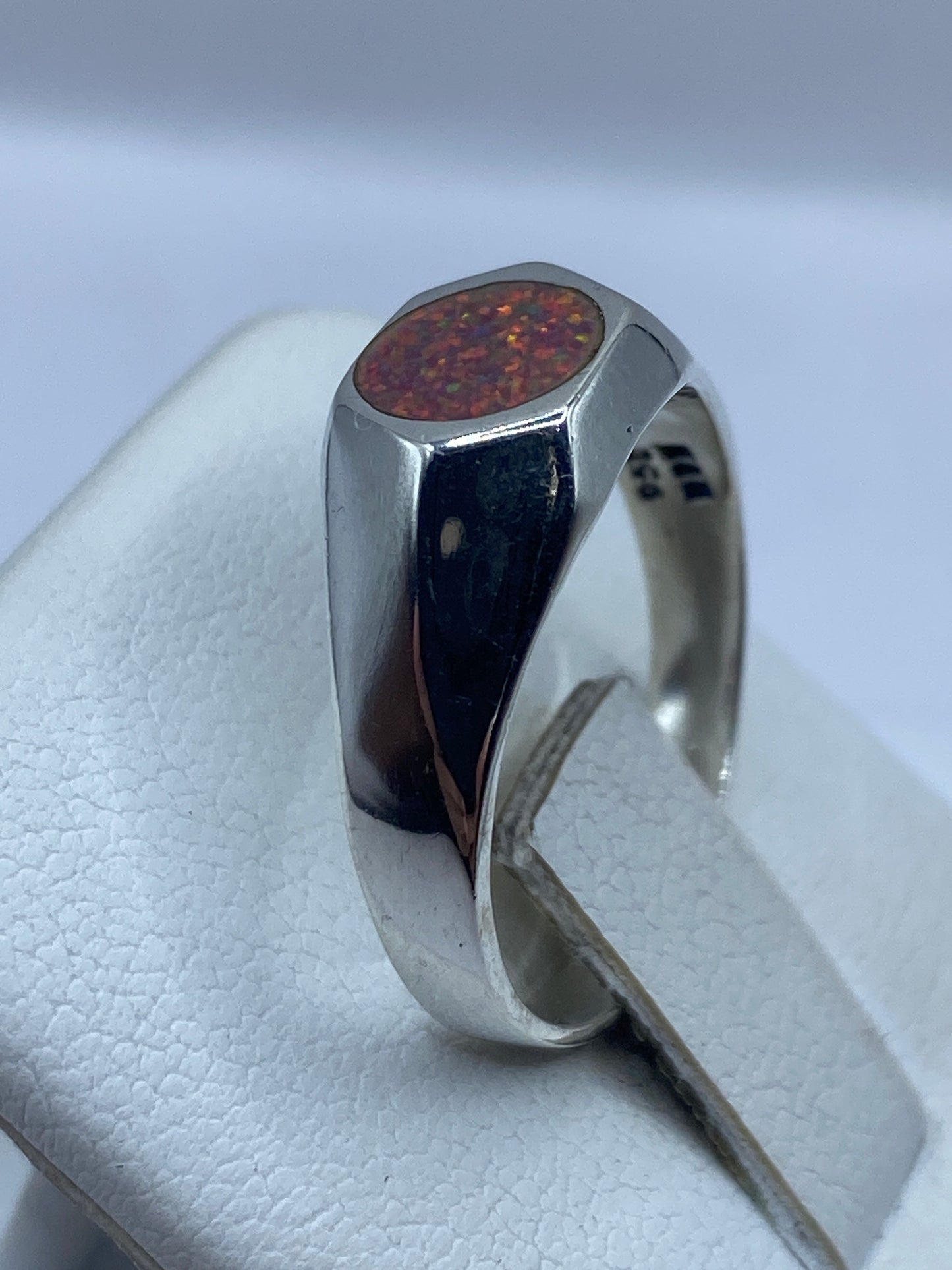 Ópalo de fuego rosa en detalle con destellos naranja, engastado en plata pura