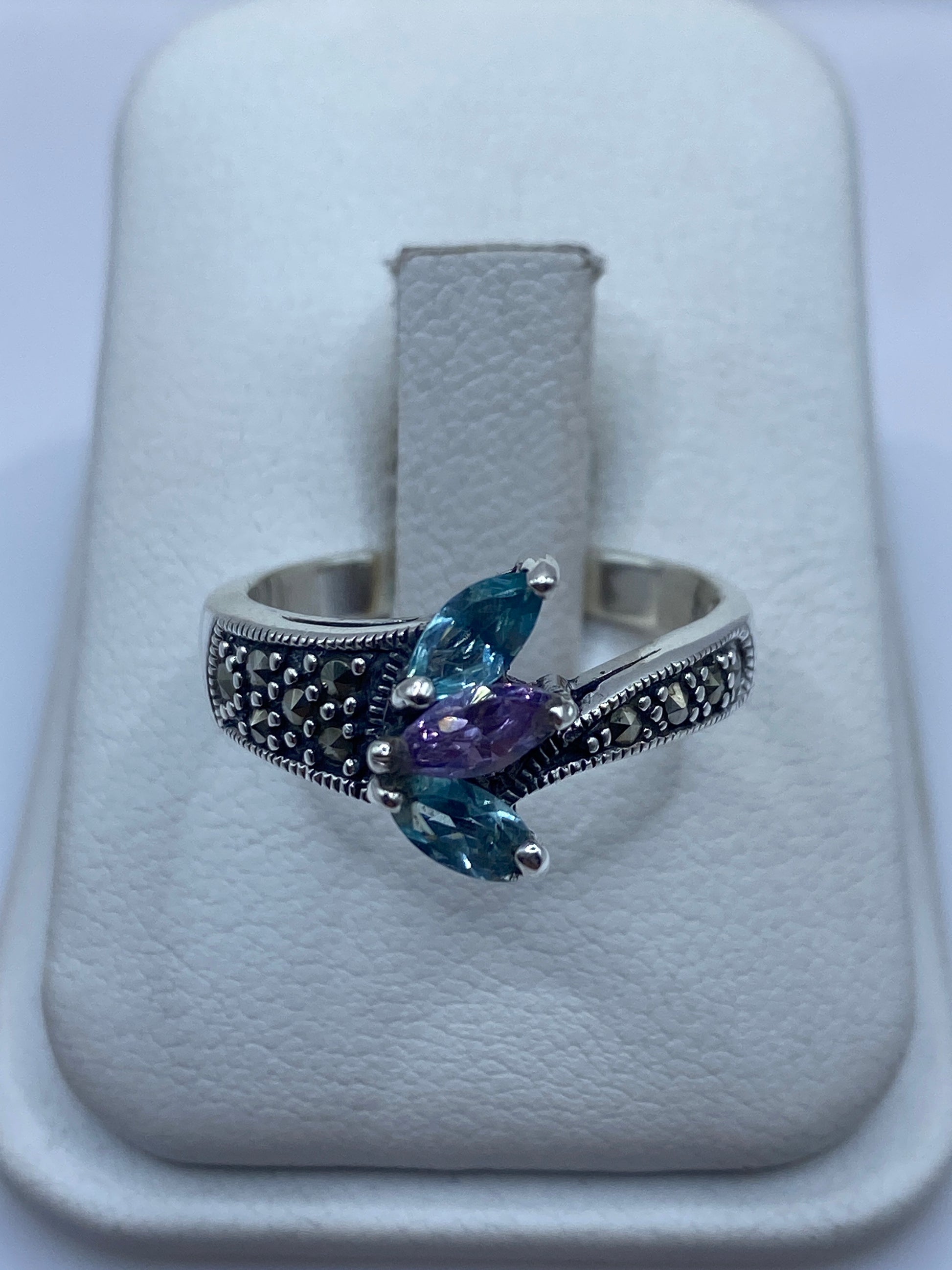 Anillo de plata .925 con circonia azul cielo y textura de perlas en joyero blanco