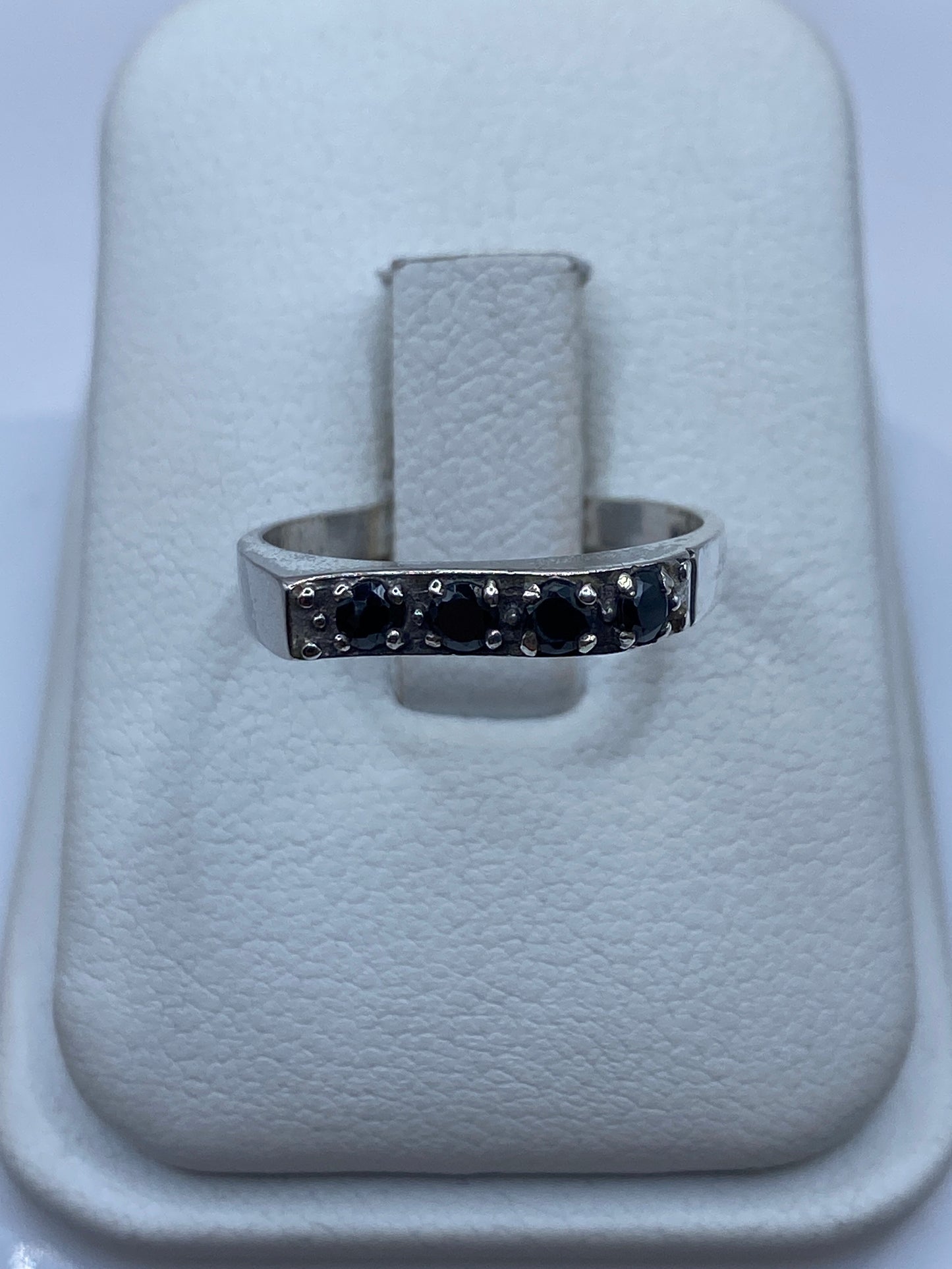 Anillo de plata minimalista con circonia negra brillante en dedo femenino