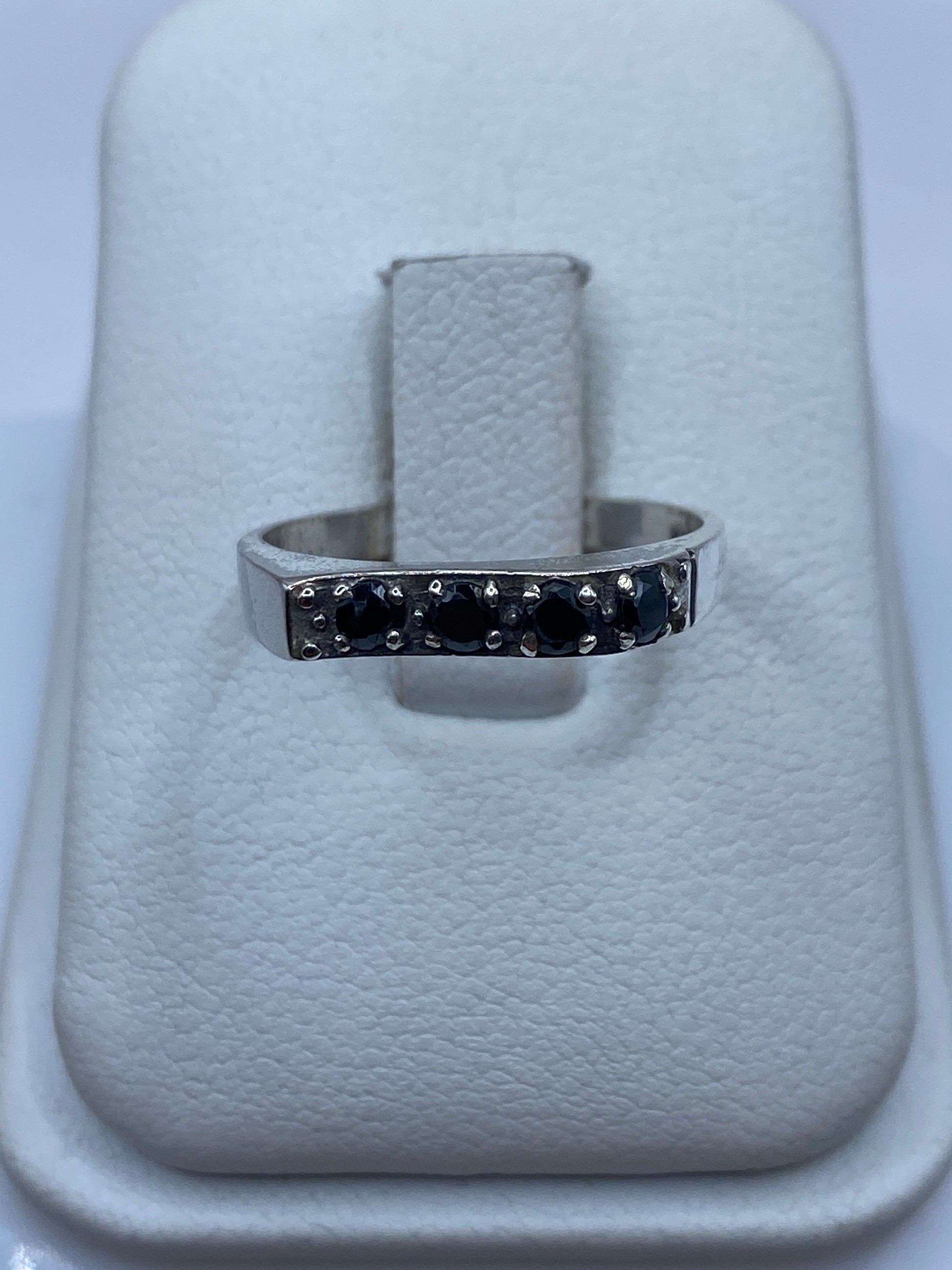 Anillo de plata minimalista con circonia negra brillante en dedo femenino