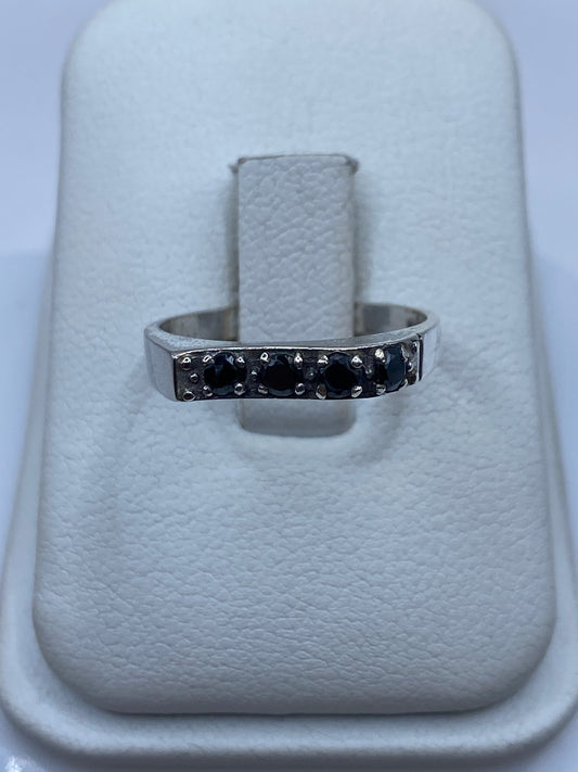 Anillo de plata minimalista con circonia negra brillante en dedo femenino
