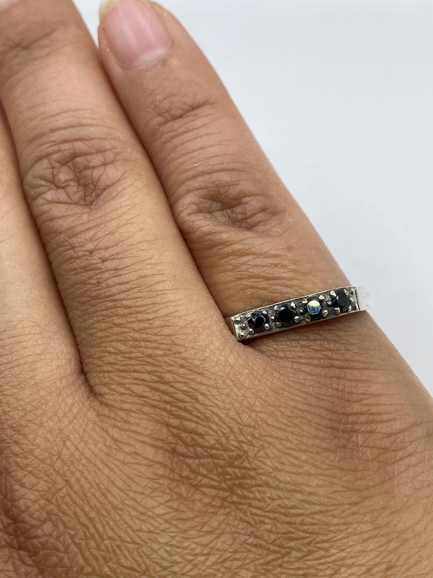 Anillo sobre fondo blanco con vista de la banda delgada y pulida en plata