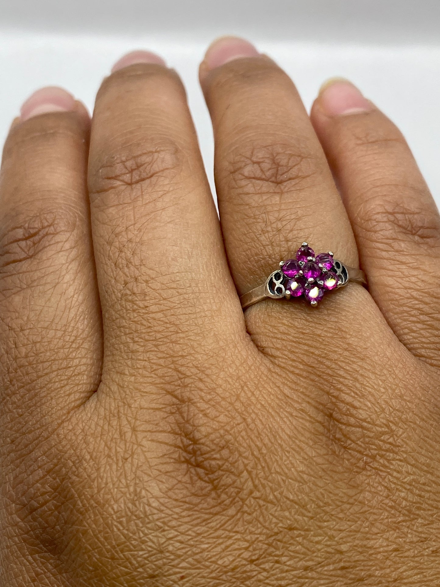 Anillo de plata en dedo de mujer luciendo la circonia rosa con luz natural