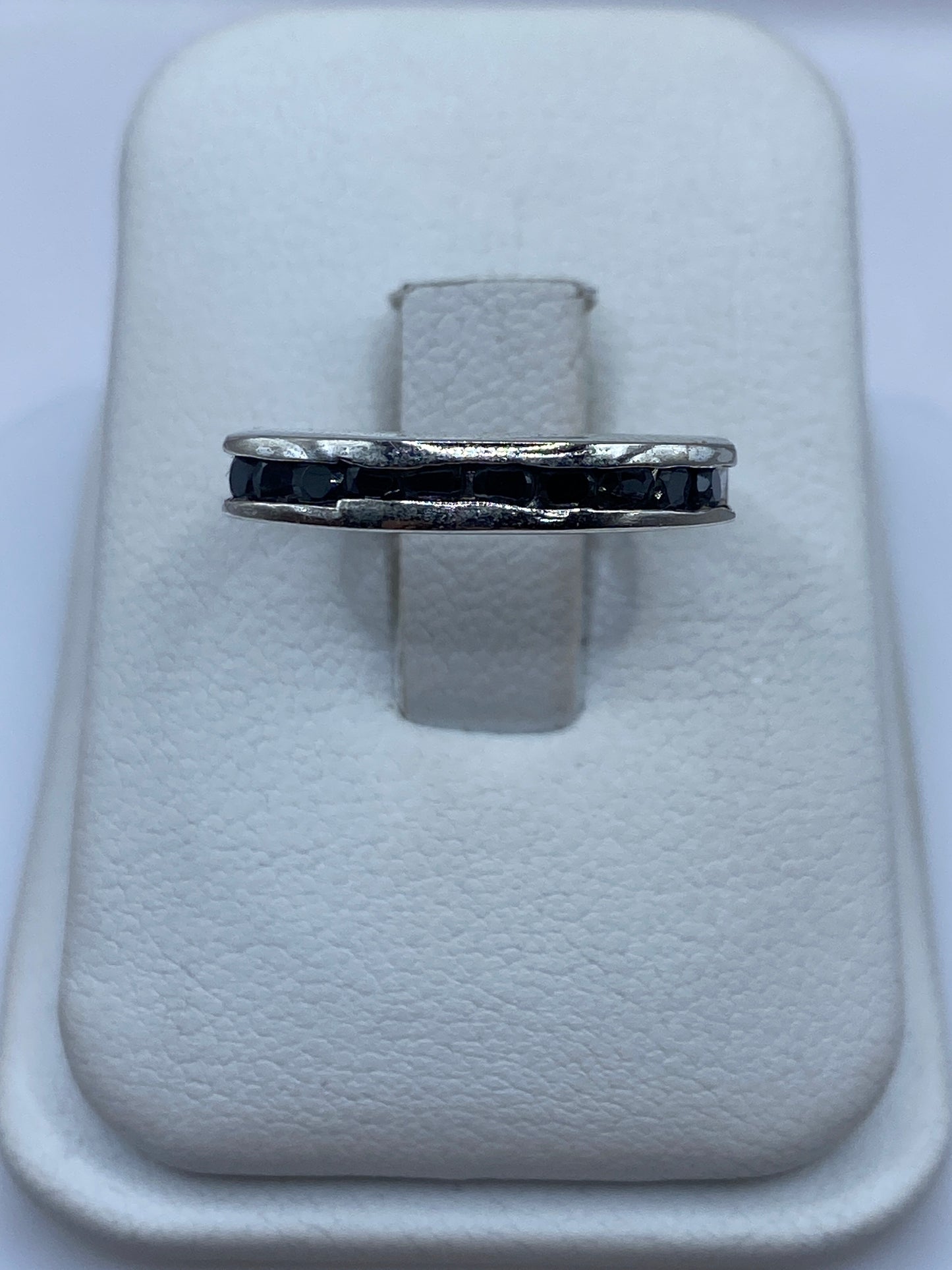 Anillo solitario de plata con circonia negra brillante, vista frontal sobre estuche blanco