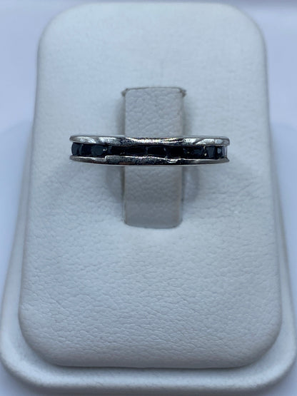 Anillo solitario de plata con circonia negra brillante, vista frontal sobre estuche blanco