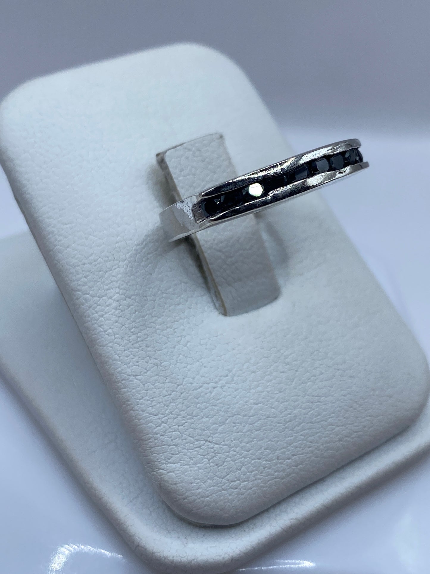 Anillo minimalista de plata .925 con piedra negra, vista lateral en mano