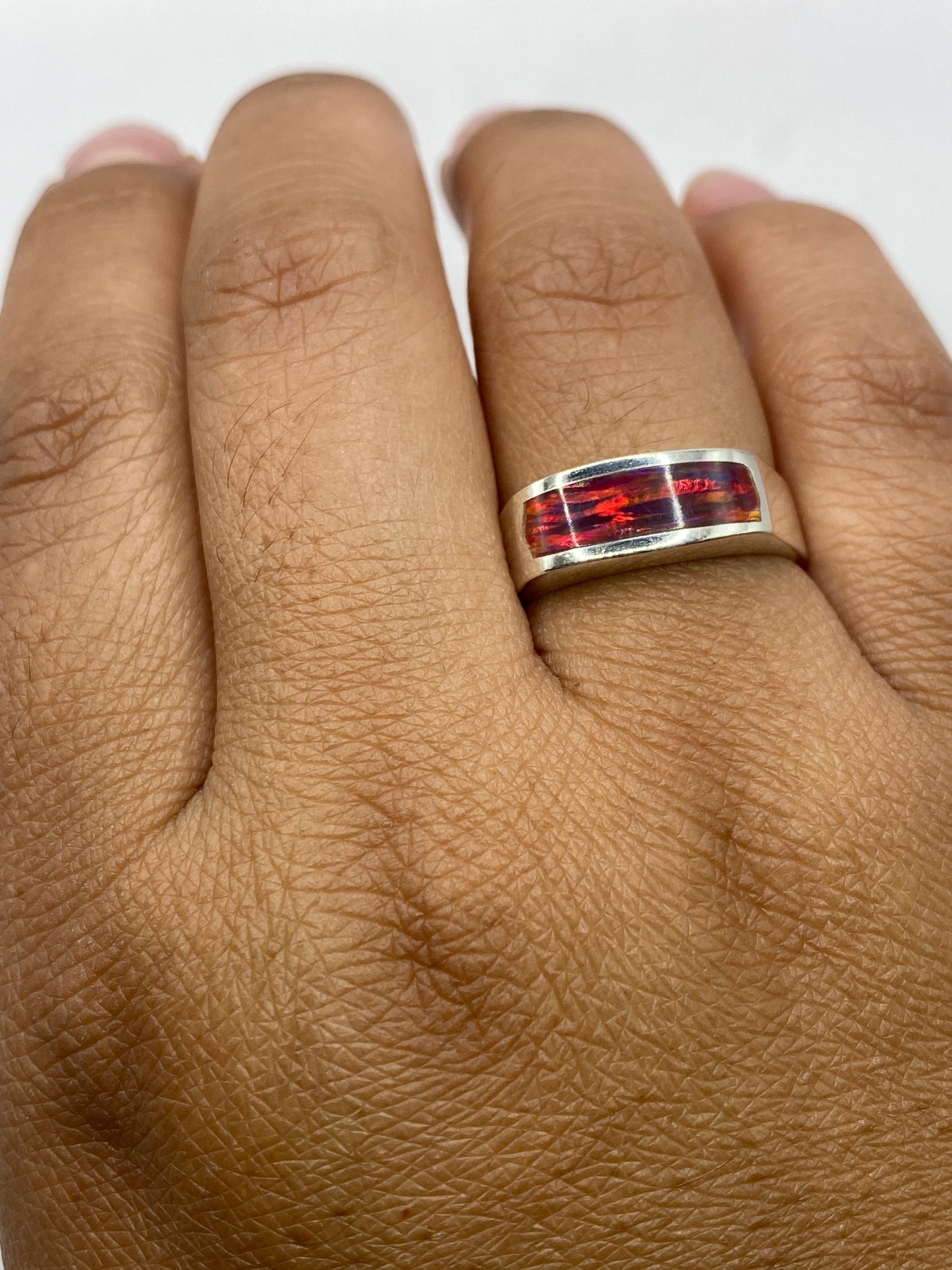 Anillo en dedo mostrando el juego de colores del ópalo de fuego natural