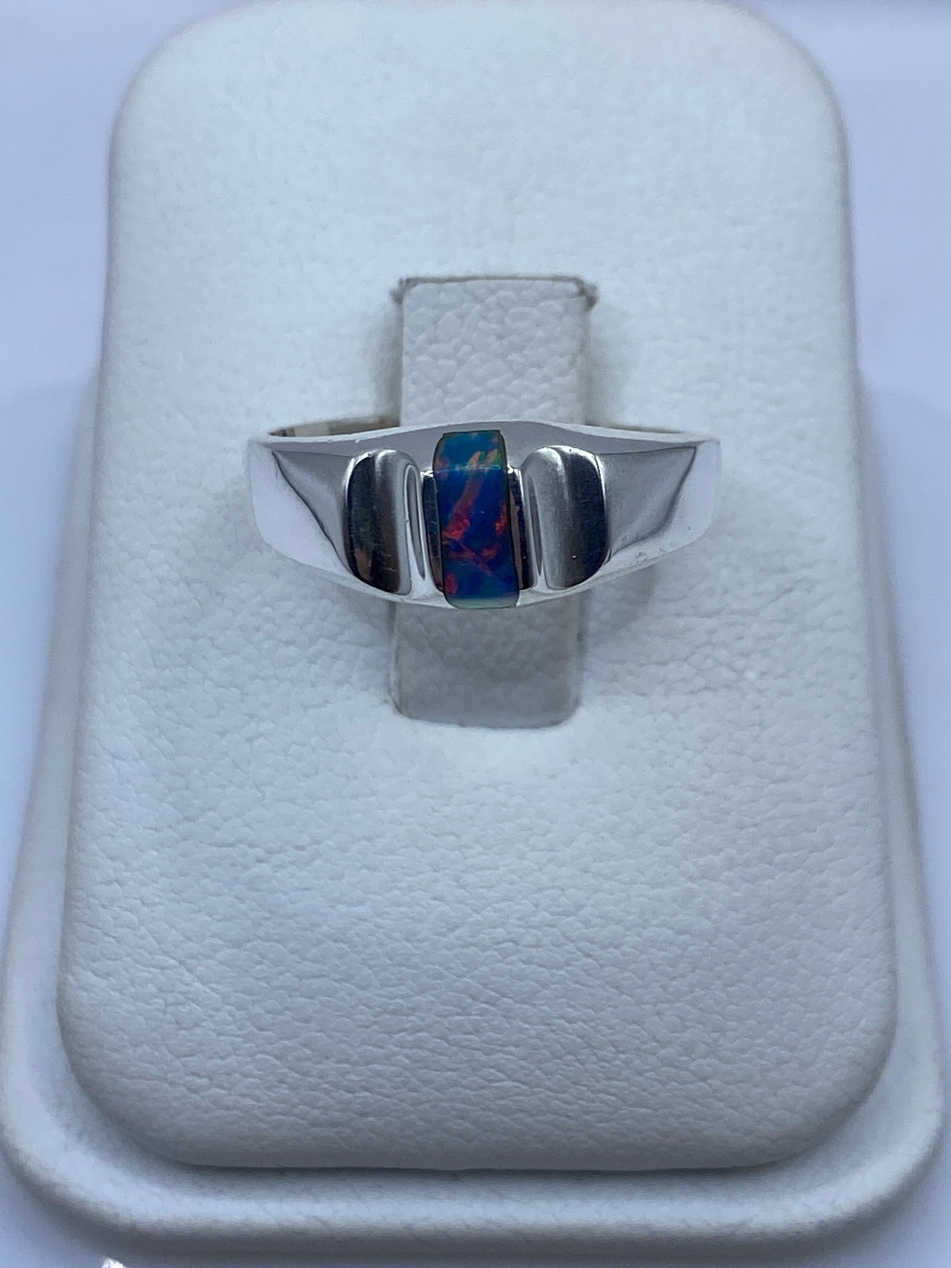 Anillo de plata solitario con ópalo de fuego azul en joyero blanco