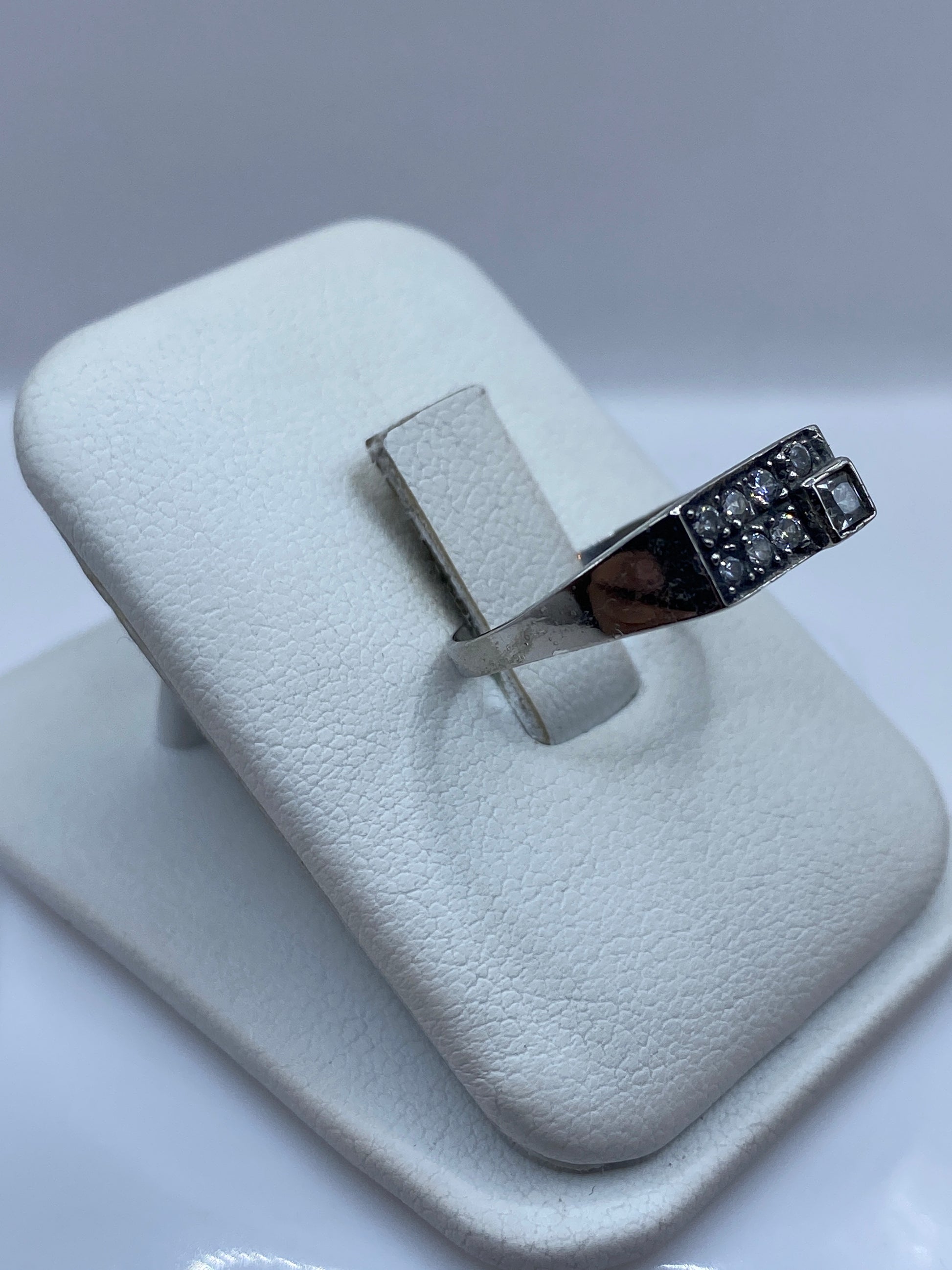 Vista frontal del anillo minimalista con piedra blanca centrada en plata .925