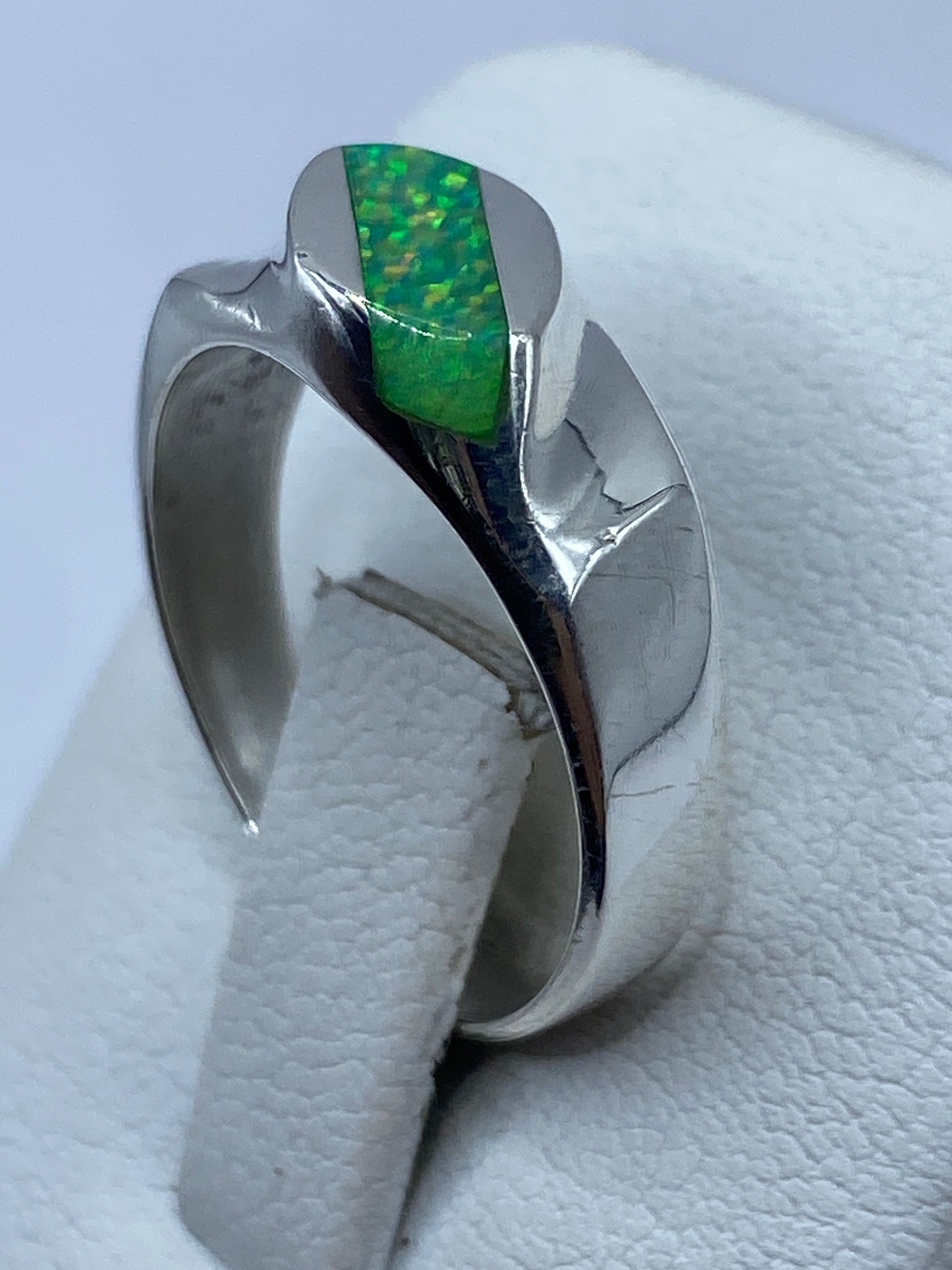 Anillo de ópalo de fuego en mano de mujer mostrando el brillo natural